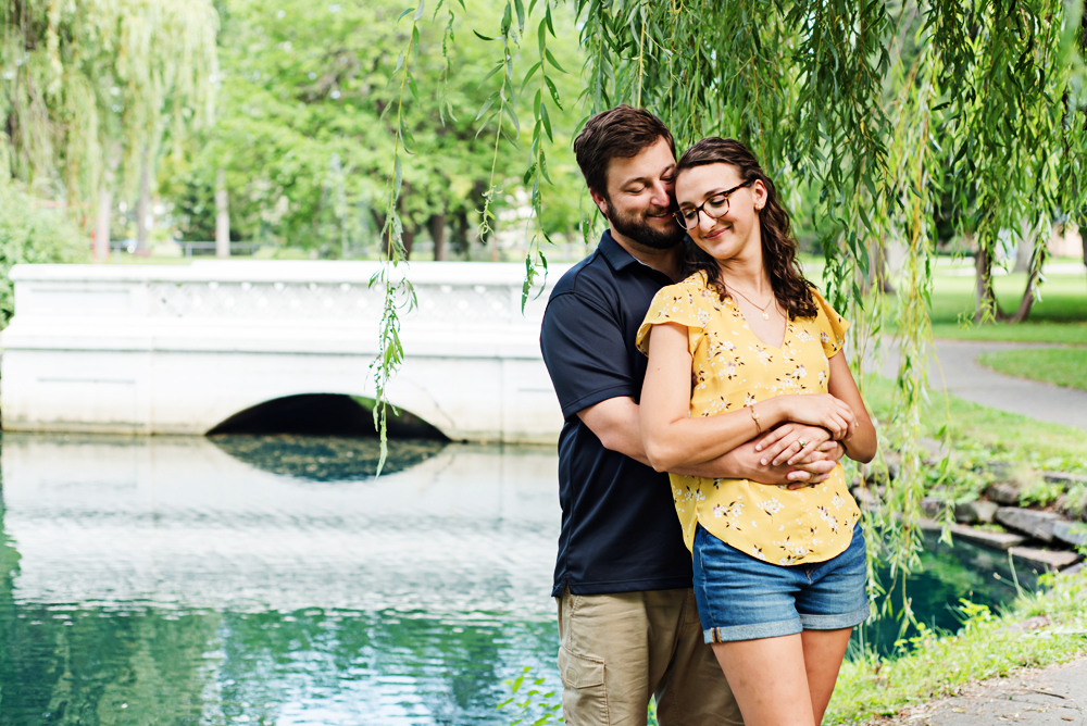 Engagement couple with bridge behind them