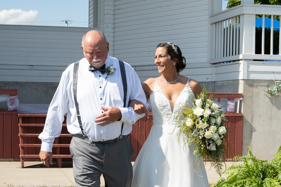 Tawas-bride walking down the aisle with father-in-law at wedding ceremony