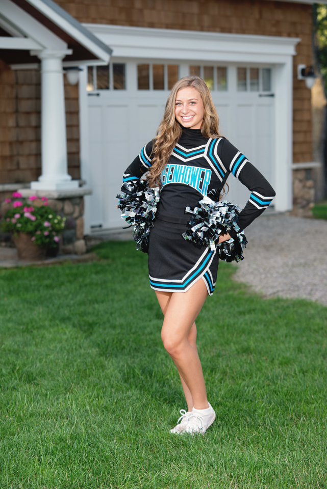 Cheerleader in her uniform and pompons.