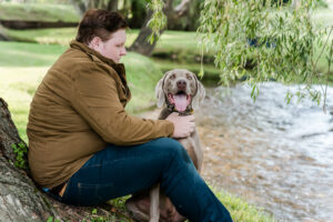 high school senior boy with his dog by the creek
