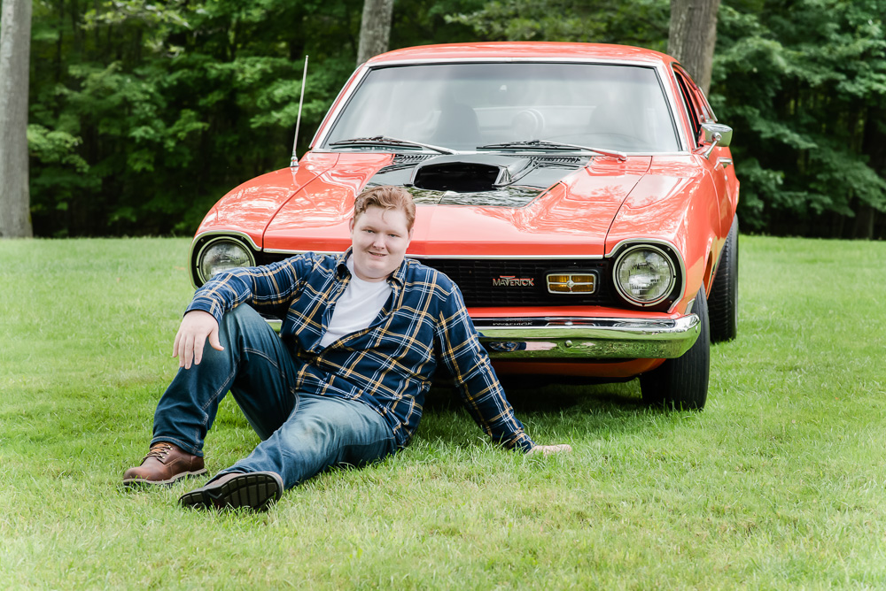 high school senior boy sitting in front of his vintage car