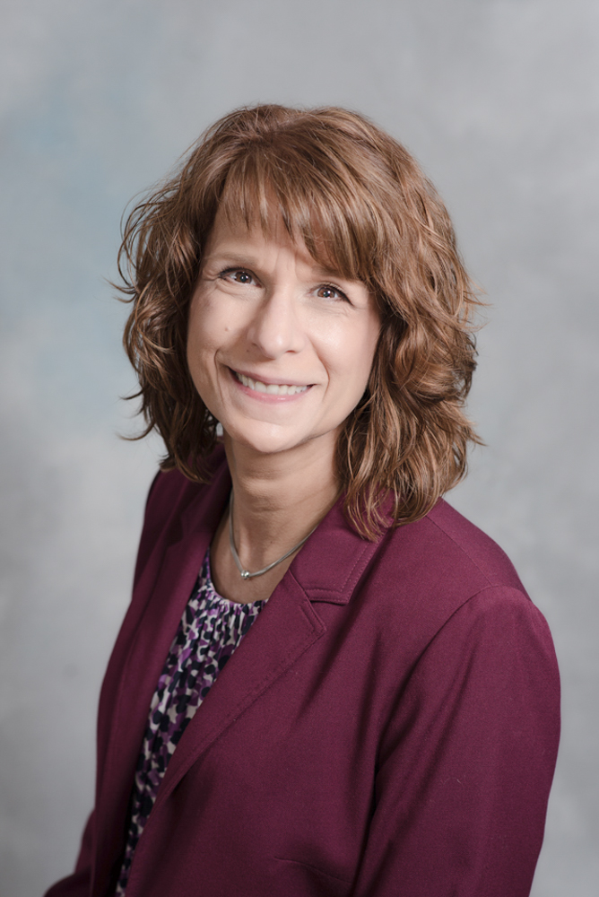 Headshot of a woman with burgandy top