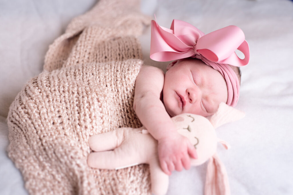 newborn in pink holding a bunny