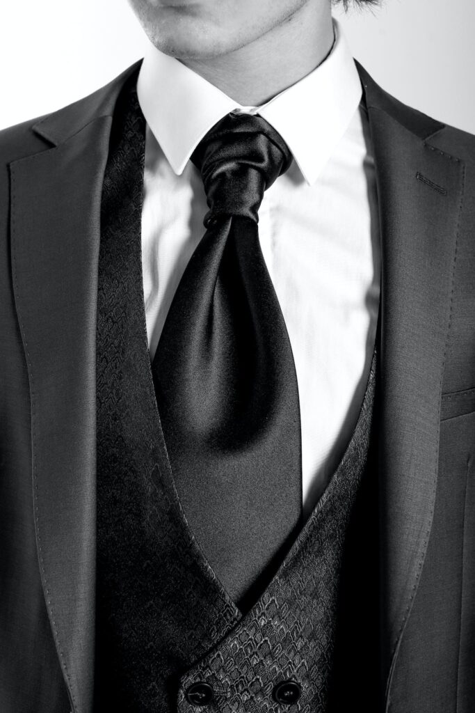 A man in a tuxedo with a black tie at a graduation party