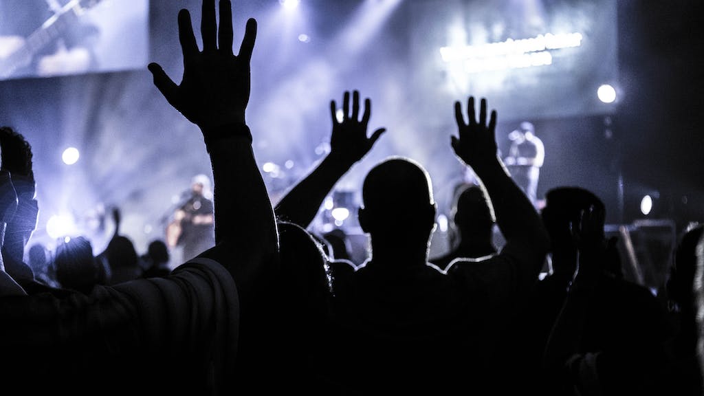 Group of People Raising Hands to music being played at a graduation party