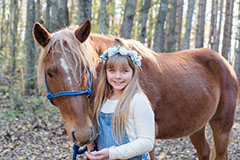girl with flower crown holding her horses lead rope