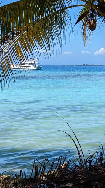 Blue waters with yacht in the background, Near Placencia, Belize