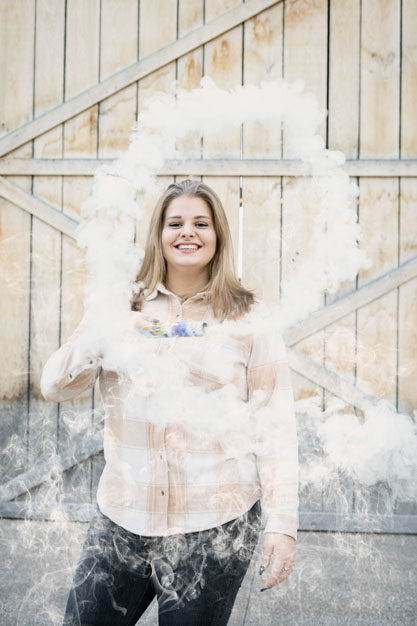 girl smiling through smoke circle