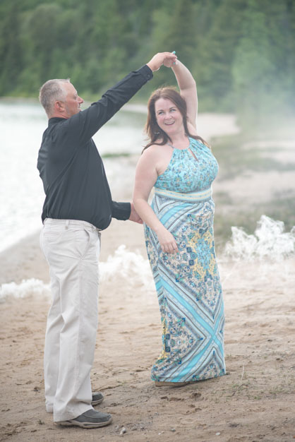 Man twirling fiance on the beach