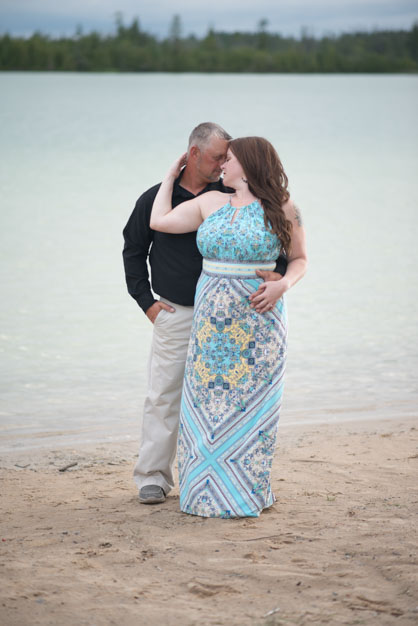 Engaged Couple standing together on the beach