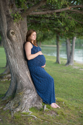 pregnant woman leaning on tree