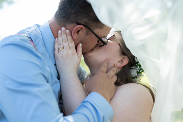 Bride and Groom kissing under veil