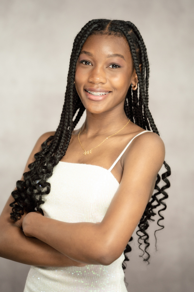 black teenager with arms crossed, smiling.