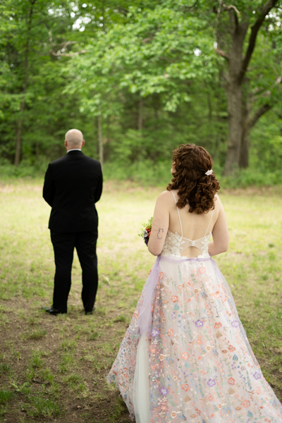 Bride walking up behind groom during a first look before the wedding.