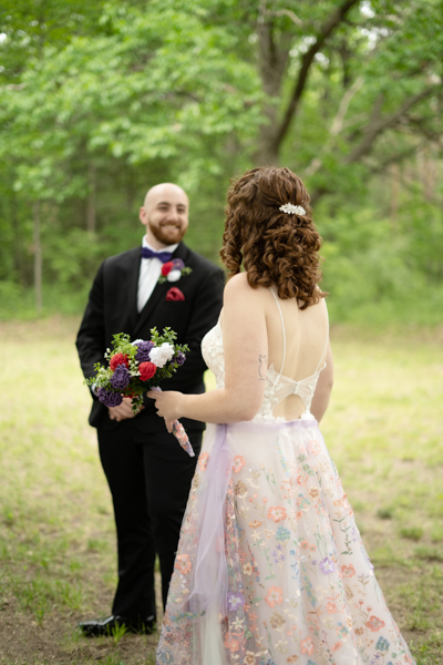 Groom turns around to look at his bride, smiling.