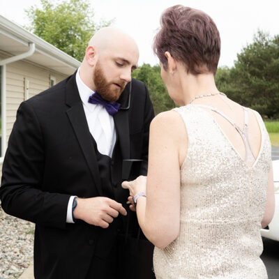 groom and mother having a discussion.  Groom on the phone.
