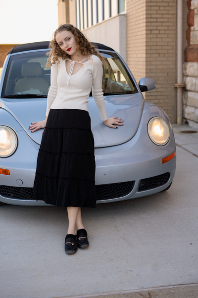 girl leaning on her gray vw bug.