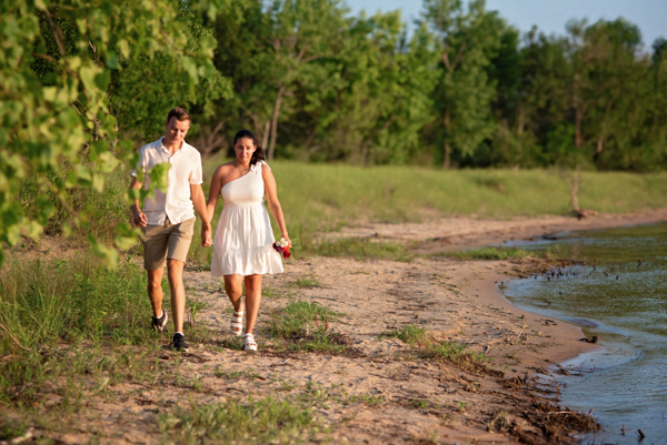 Young man surprising his girlfriend with a proposal on the beach in East Tawas.