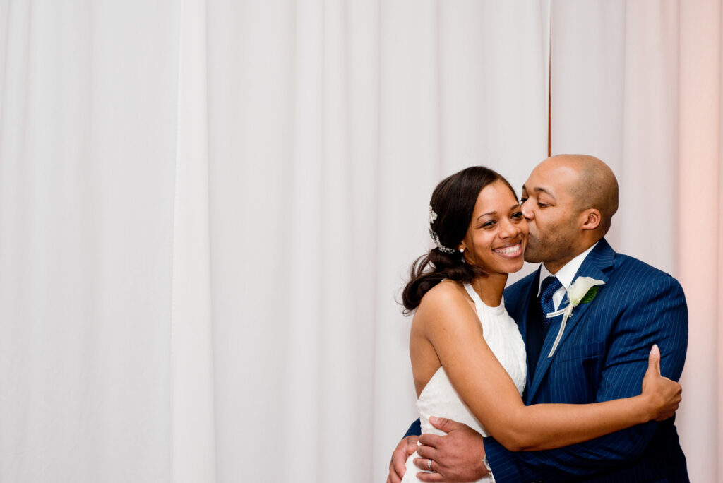 wedding couple - groom kissing bride on cheek